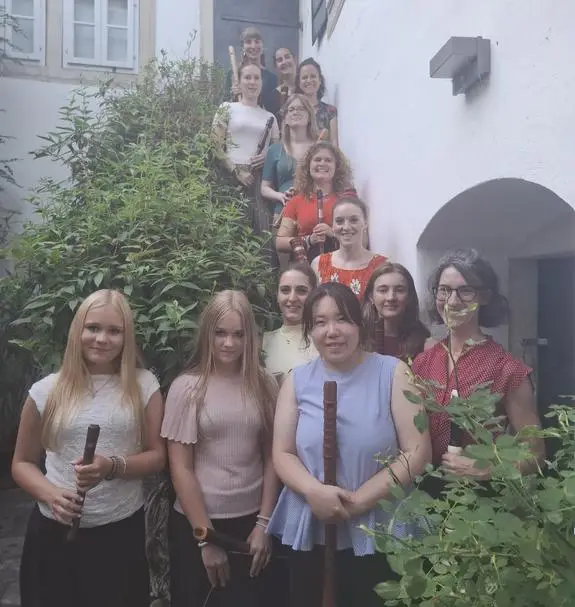 Blockflötenensemble von Frauen posiert auf einer Treppe in Österreich vor einem Gebäude.